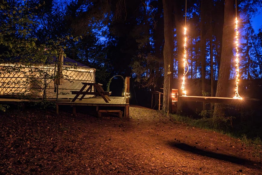 Noční okolí jurty Rozárky. s osvícenou houpačkou.