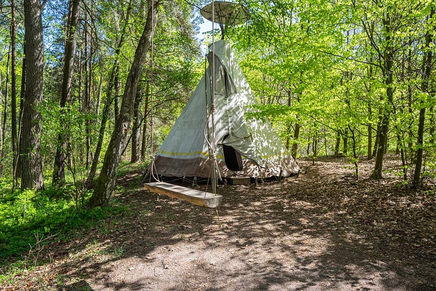 Tradiční týpí umístěné vedle jurty Rozárky, mezi stromy v lese. Ideální pro naplněný dětských snů a jejich indiánské duše.